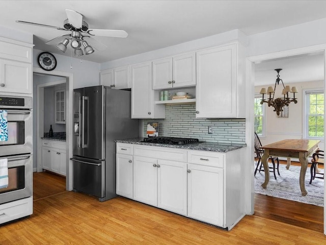 kitchen featuring stainless steel appliances, light wood-type flooring, backsplash, and white cabinets