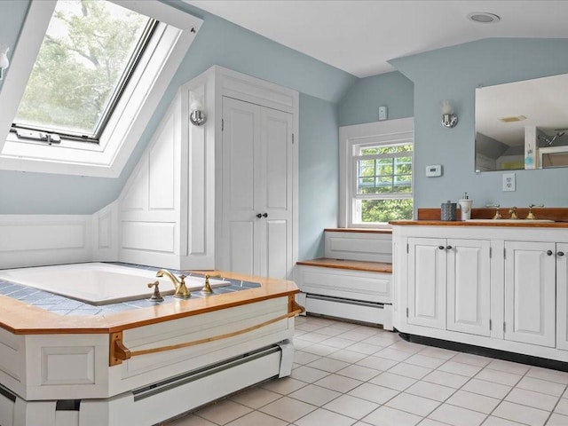 bathroom with vaulted ceiling, a skylight, baseboard heating, vanity, and tile patterned floors