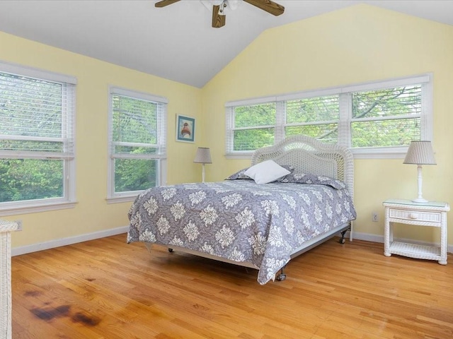 bedroom with multiple windows, light wood-style flooring, lofted ceiling, baseboards, and ceiling fan