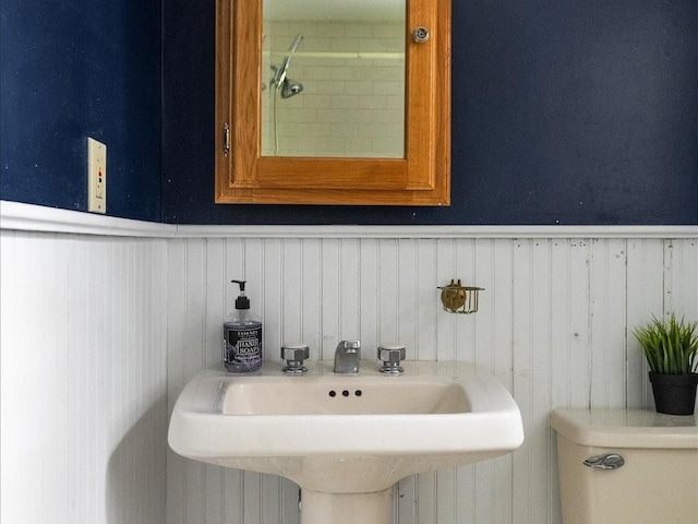 bathroom featuring a sink and a wainscoted wall