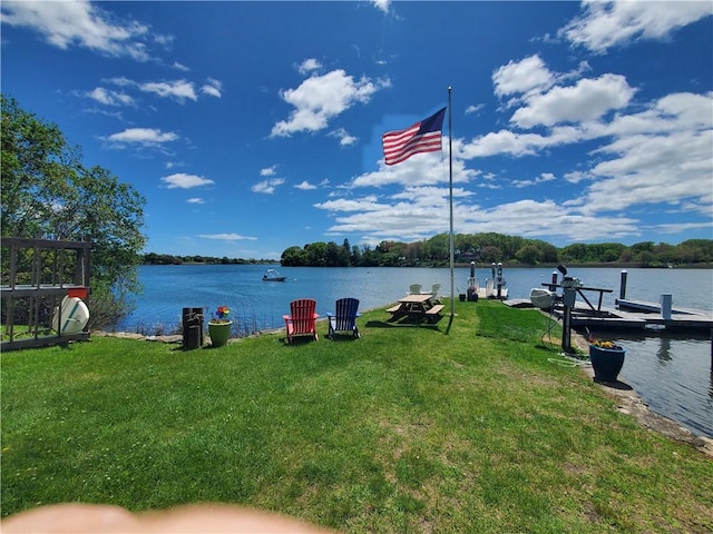 dock area with a lawn and a water view