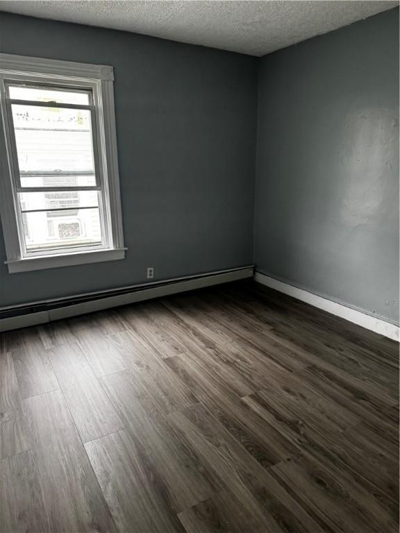 342 Paradis Ave, Woonsocket, RI 02895 - unfurnished room with dark wood-style flooring, a textured ceiling, baseboard heating, and baseboards