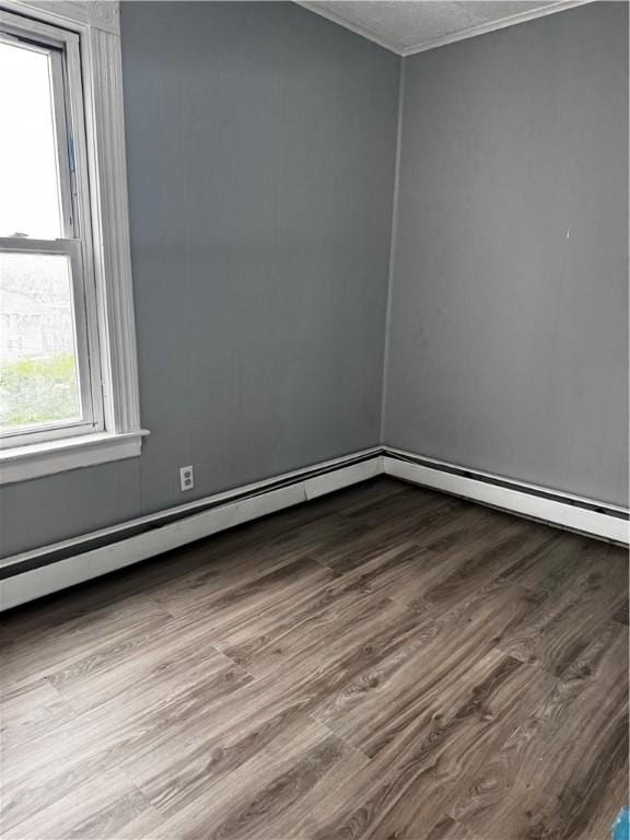342 Paradis Ave, Woonsocket, RI 02895 - spare room featuring dark wood-type flooring, healthy amount of natural light, a baseboard radiator, crown molding, and a baseboard heating unit
