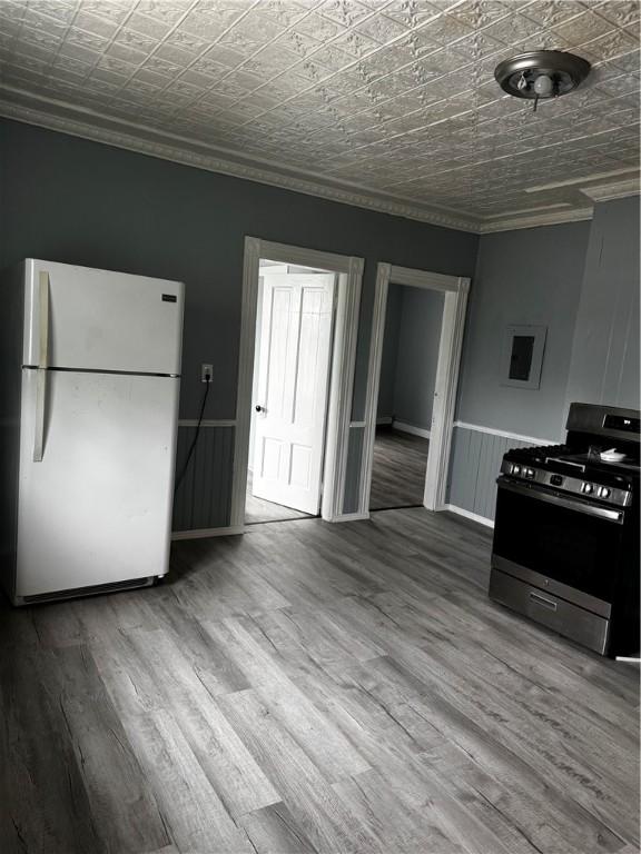 342 Paradis Ave, Woonsocket, RI 02895 - kitchen featuring freestanding refrigerator, stainless steel range with gas cooktop, ornamental molding, an ornate ceiling, and wood finished floors