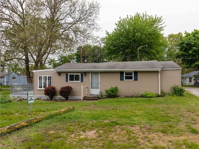 46 E Andrew Comstock Rd, Warwick, RI 02886 - single story home featuring a front yard, a wooden deck, and entry steps