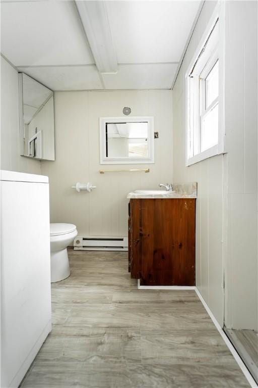 46 E Andrew Comstock Rd, Warwick, RI 02886 - bathroom with a baseboard heating unit, toilet, wood finished floors, and vanity
