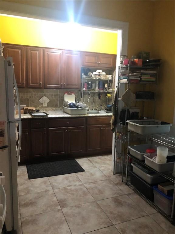 149 Peace St, Providence, RI 05290 - kitchen with freestanding refrigerator, light countertops, tasteful backsplash, and light tile patterned floors