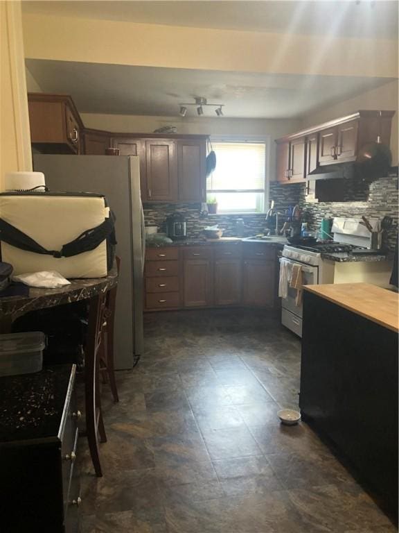 10 Bellevue Ave, Providence, RI 02907 - kitchen featuring white gas range, tasteful backsplash, dark countertops, a sink, and under cabinet range hood