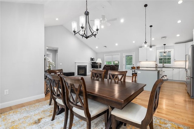 1351 Pippin Orchard Rd, Cranston, RI 02921 - dining room with high vaulted ceiling, a chandelier, a glass covered fireplace, light wood-style flooring, and recessed lighting
