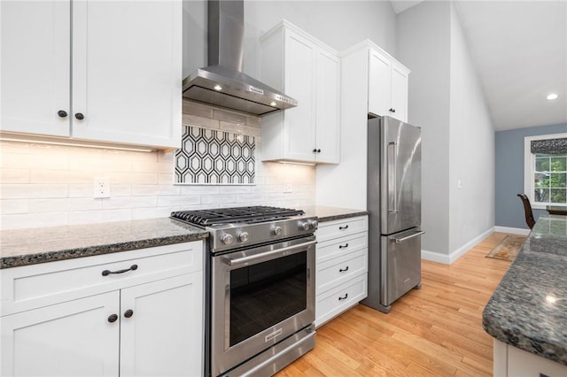 1351 Pippin Orchard Rd, Cranston, RI 02921 - kitchen featuring stainless steel appliances, wall chimney range hood, white cabinetry, dark stone counters, and tasteful backsplash