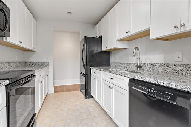 217 Hope St Unit 3, Bristol, RI 02809 - kitchen with black appliances, a sink, white cabinets, and light stone counters