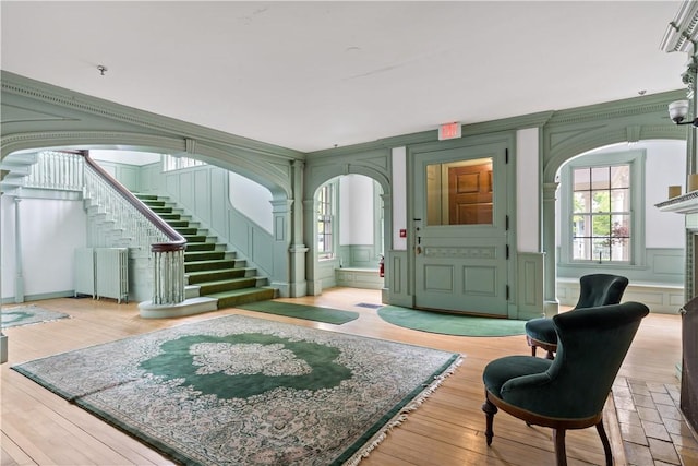 217 Hope St Unit 3, Bristol, RI 02809 - foyer with arched walkways, stairs, a decorative wall, and wood finished floors