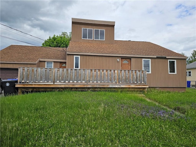 121 Friendship St, North Providence, RI 02904 - back of property featuring a lawn, a garage, roof with shingles, and a deck