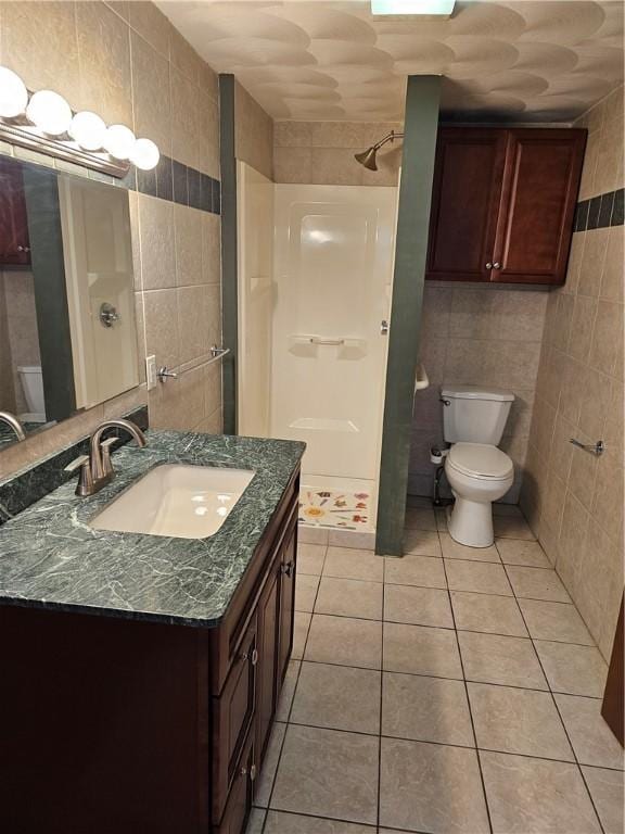 121 Friendship St, North Providence, RI 02904 - full bathroom featuring tile walls, a stall shower, toilet, tile patterned floors, and vanity