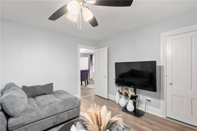 living room featuring wood finished floors, ceiling fan, and baseboards