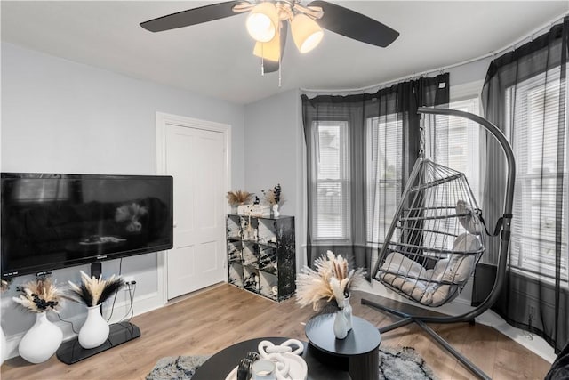 sitting room featuring wood finished floors, healthy amount of natural light, and ceiling fan