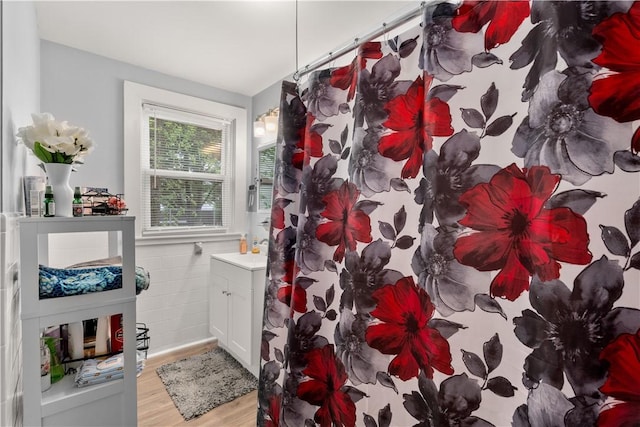 full bath featuring wood finished floors, a shower with shower curtain, and vanity