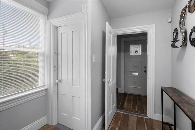 hall with dark wood-style floors and baseboards