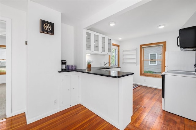 10 Curry Ave, Newport, RI 02840 - kitchen featuring white cabinetry, dark wood-style flooring, a peninsula, dark countertops, and range