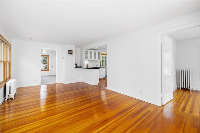 10 Curry Ave, Newport, RI 02840 - unfurnished living room featuring radiator heating unit, wood-type flooring, and baseboards
