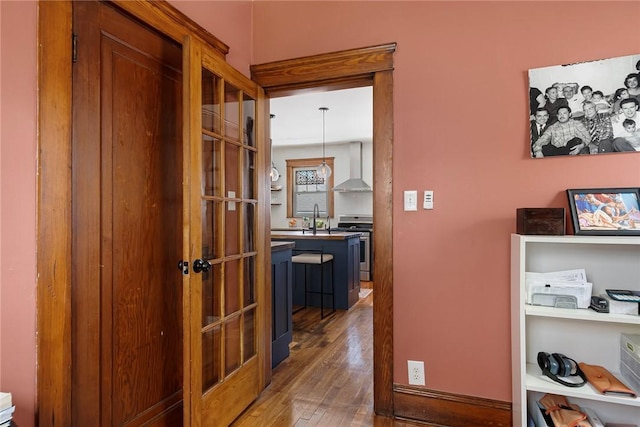 corridor featuring hardwood / wood-style flooring and a sink