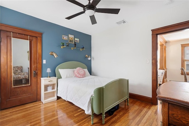 bedroom featuring wood finished floors, baseboards, and ceiling fan