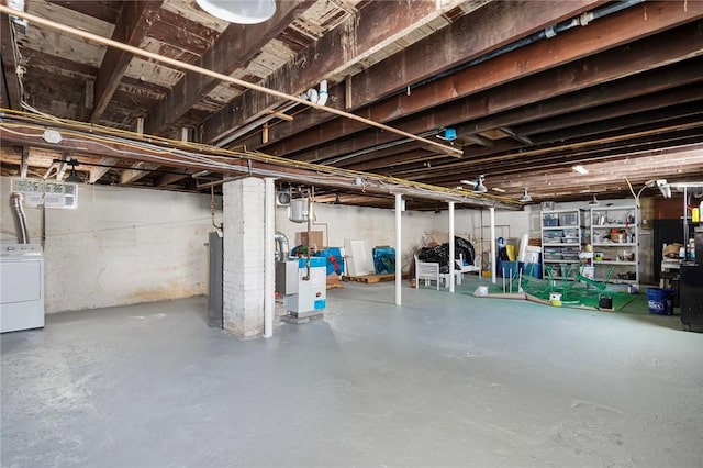unfinished below grade area with washer / dryer and a heating unit