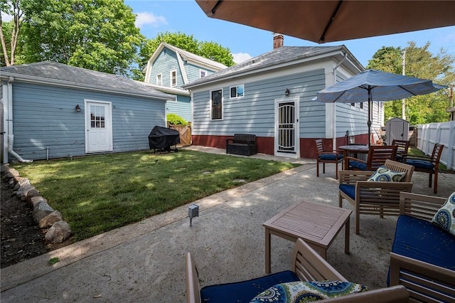 rear view of house featuring an outdoor structure, a patio, and a chimney