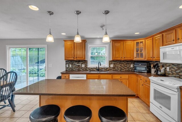 23 Blissdale Ave, Cumberland, RI 02864 - kitchen featuring white appliances, a sink, light tile patterned floors, a kitchen bar, and recessed lighting