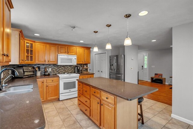 23 Blissdale Ave, Cumberland, RI 02864 - kitchen with white appliances, a sink, light tile patterned floors, a breakfast bar area, and a center island