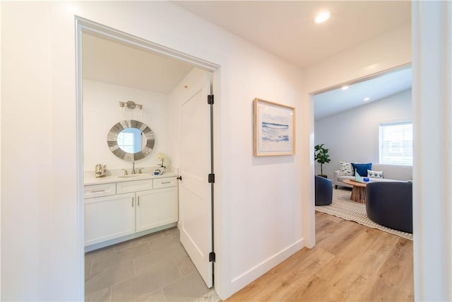 32 Exchange St Unit 101, East Greenwich, RI 02818 - hallway featuring a sink, recessed lighting, vaulted ceiling, baseboards, and light wood-type flooring