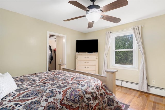 19 S Locust Ave, North Providence, RI 02911 - bedroom with wood finished floors, a walk in closet, a ceiling fan, and baseboard heating