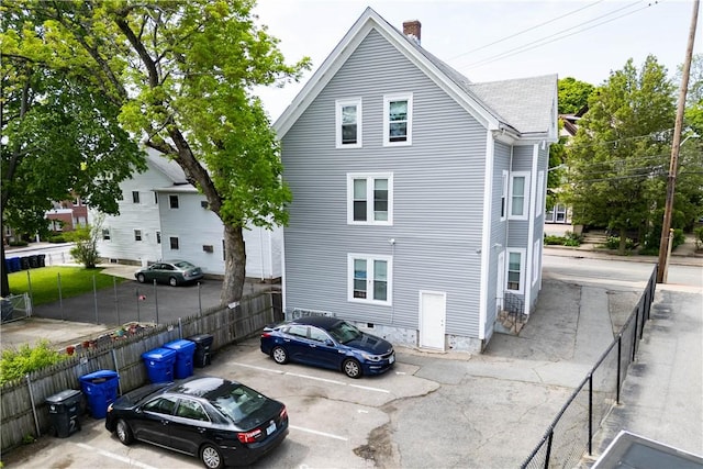 115 Division St, Pawtucket, RI 02860 - back of house with uncovered parking and a chimney