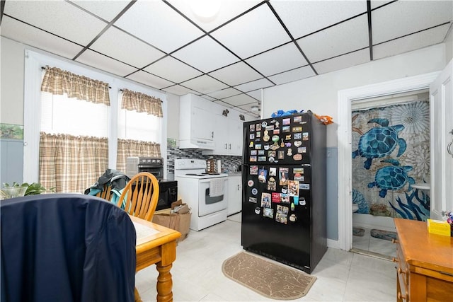 115 Division St, Pawtucket, RI 02860 - kitchen with white electric stove, freestanding refrigerator, white cabinets, under cabinet range hood, and backsplash