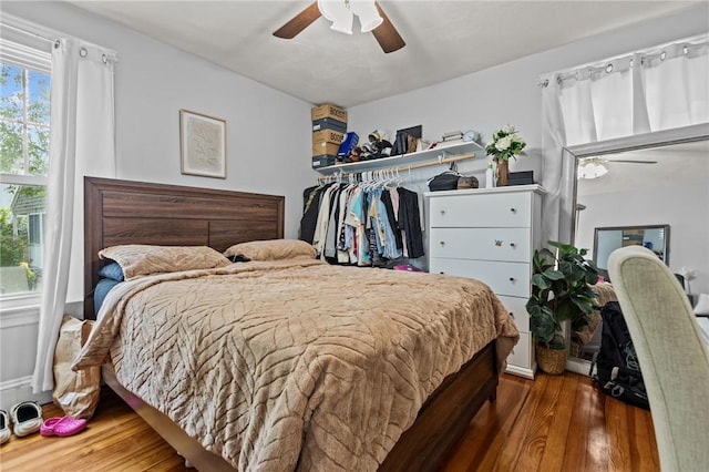 bedroom with wood finished floors, a ceiling fan, and a closet