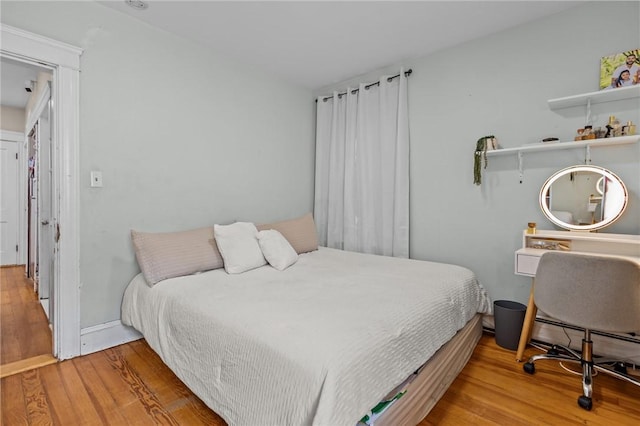 bedroom featuring wood finished floors and baseboards