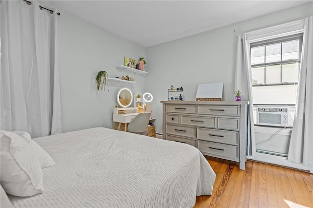 bedroom with cooling unit and light wood-type flooring