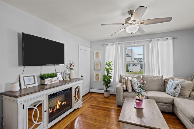 living area with ceiling fan, baseboards, and light wood-style floors
