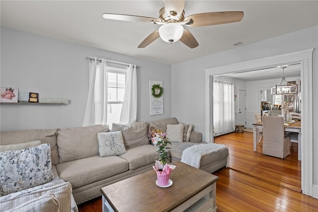 living area with healthy amount of natural light, wood finished floors, and ceiling fan