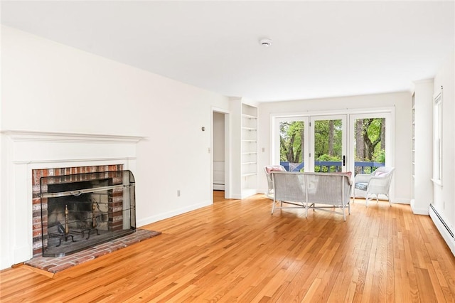 40 Wood Ave, Narragansett, RI 02882 - unfurnished living room with light wood-style flooring, baseboards, built in shelves, baseboard heating, and a fireplace