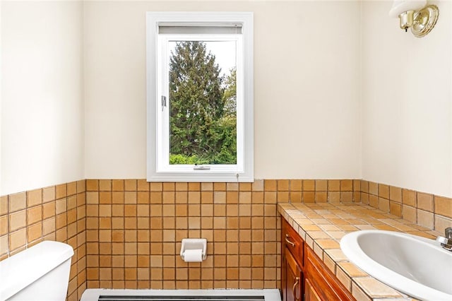 40 Wood Ave, Narragansett, RI 02882 - half bathroom with toilet, tile walls, vanity, wainscoting, and baseboard heating