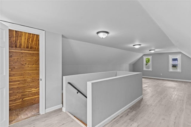 additional living space featuring light wood finished floors and vaulted ceiling