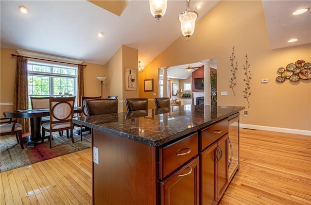 500 Mendon Rd Unit 116, Cumberland, RI 02864 - kitchen featuring decorative columns, light wood-type flooring, a kitchen island, vaulted ceiling, and brown cabinets