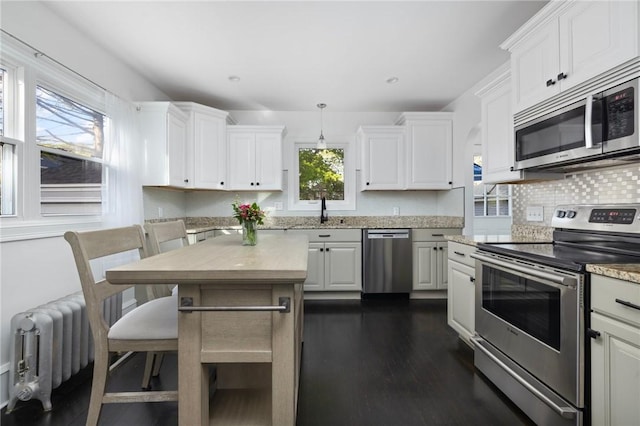 224 Raleigh Ave, Pawtucket, RI 02860 - kitchen featuring stainless steel appliances, white cabinetry, radiator heating unit, a sink, and tasteful backsplash