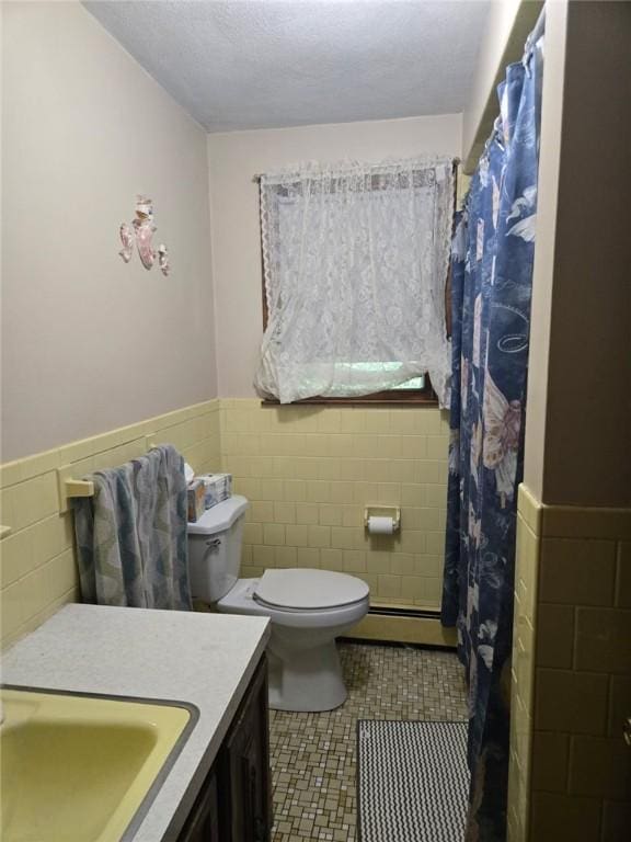 17 Woodcliff Ave, North Providence, RI 02911 - bathroom featuring baseboard heating, tile walls, toilet, wainscoting, and tile patterned floors
