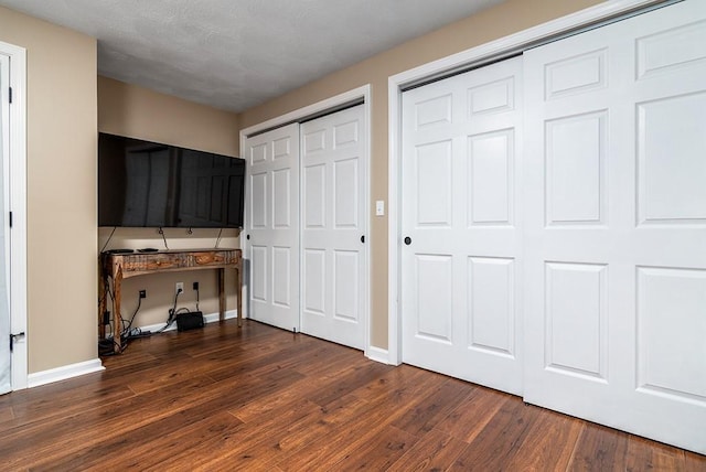 26 Ivy Hollow Ct, Cranston, RI 02921 - unfurnished bedroom with multiple closets, dark wood finished floors, and baseboards