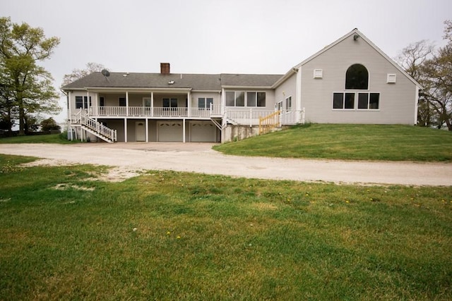 3622 Main Rd, Tiverton, RI 02878 - back of house featuring stairway, driveway, an attached garage, a chimney, and a lawn