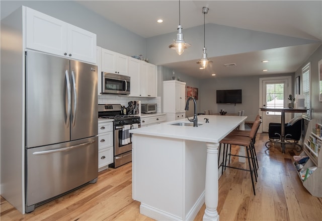 24 Southmayd St, Newport, RI 02840 - kitchen with appliances with stainless steel finishes, a sink, white cabinets, light wood-type flooring, and vaulted ceiling