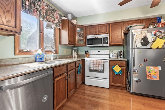 607 Brookhaven Ln, Woonsocket, RI 02895 - kitchen featuring stainless steel appliances, a sink, brown cabinetry, and light wood-style floors