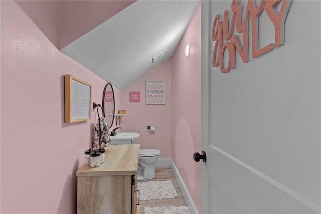 261 Columbus Ave, Pawtucket, RI 02861 - bathroom featuring vanity, wood finished floors, toilet, lofted ceiling, and baseboards
